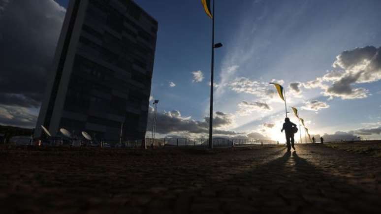 Mulher passa pelo Congresso Nacional, em Brasília, na terça-feira (30); imprensa estrangeira destaca problemas à frente no cenário pós-impeachment 