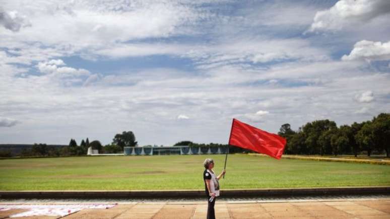 Apoiadora do PT diante do Palácio do Alvorada antes de declaração de Dilma Rousseff sobre impeachment; imprensa internacional reconhece legalidade de processo, mas questiona aspectos da legitimidade de novo governo 