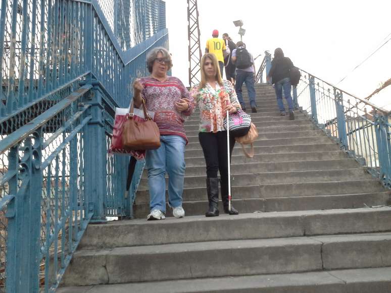 Portadora de deficiência visual, Sandra R. Lima tem de contar com a ajuda de amigas para subir e descer as escadas da estação de trem do Riachuelo – entre Maracanã e Engenho de Dentro. É o seu caminho diário para o trabalho.