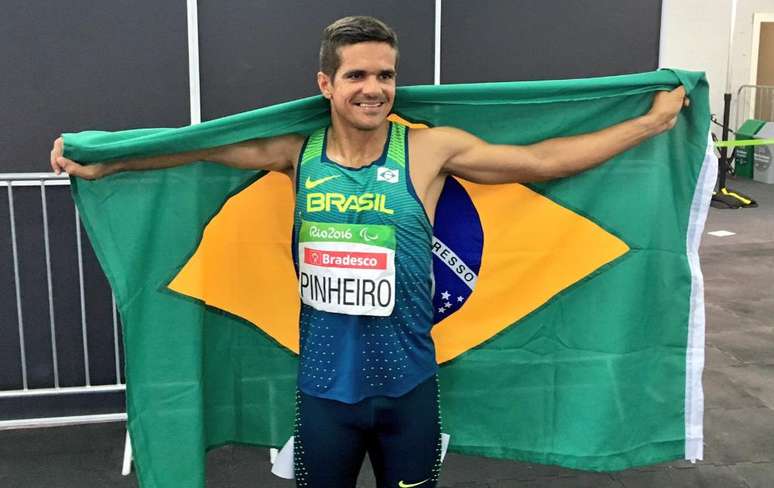Edson Pinheiro comemora sua primeira medalha nos Jogos Paralímpicos com a bandeira brasileira