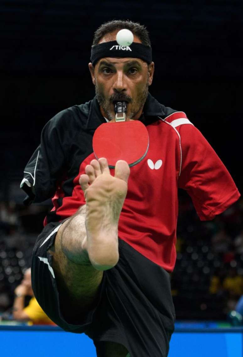 O egípcio Ibrahim Hamadtou levanta a bola com os dedos dos pés antes de sacar durante prova de tênis de mesa paralímpico