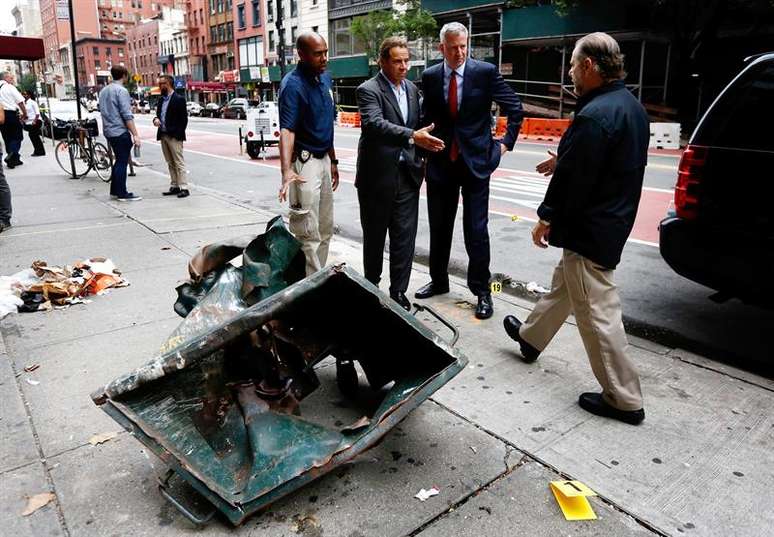 O Prefeito da cidade de Nova York Bill de Blasio, o governador do Estado de Nova York Andrew Cuomo e policiais ao lado de lixeira onde uma bomba explodiu no bairro de Chelsea. 