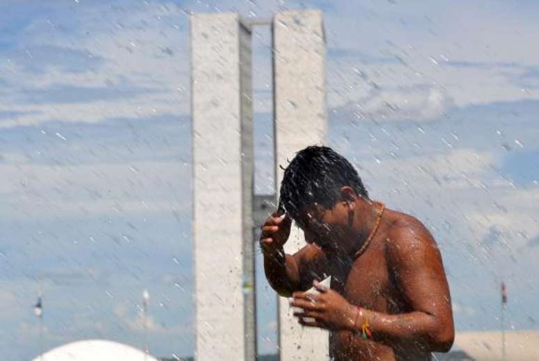 Para fugir do calor e da seca, homem molha o corpo na Esplanada dos Ministérios, em Brasília  