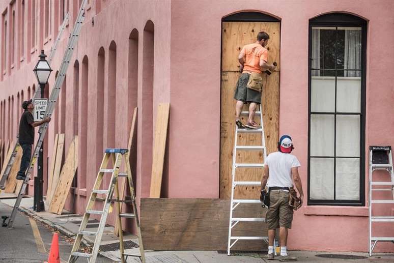 Habitantes de Charleston instalam proteções em portas e janelas para evitar danos causados pelos vendavais do furacão Matthew