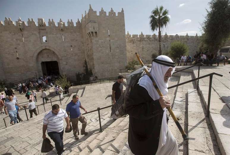 Palestino caminha em direção à mesquita de Al Aqsa para assistir às orações desta sexta-feira em Jerusalém
