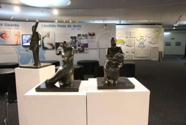 Três esculturas em bronze sobre suporte de mármore. São três formas humanas, cada um tocando um instrumento diferente. Uma das esculturas está em pé, e outras duas sentadas. Faz parte da série “Formas de um Choro”.
