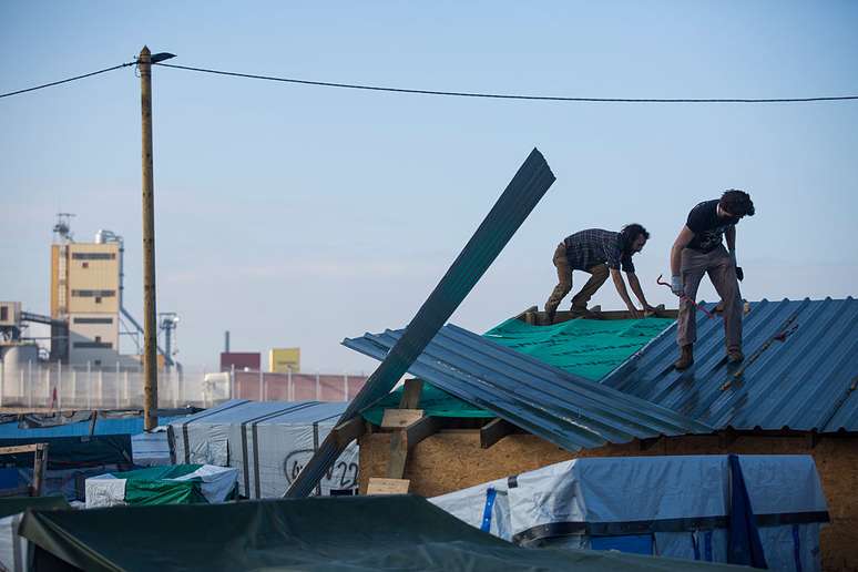 Barracos são desmontados no acampamento de Calais, na França