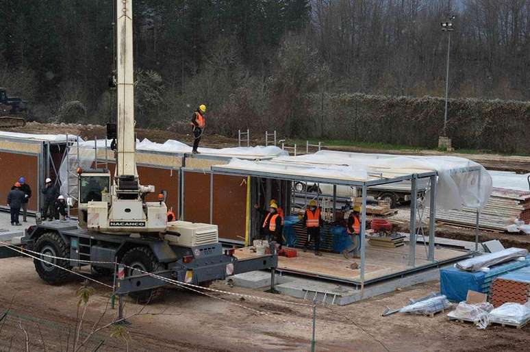 Homens trabalham na construção de residências para vítimas de terremotos que têm sacudido Amatrice nos últimos meses