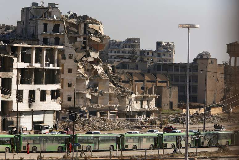 Ônibus aguardam em área controlada pelo governo para a retirada de civis de Aleppo