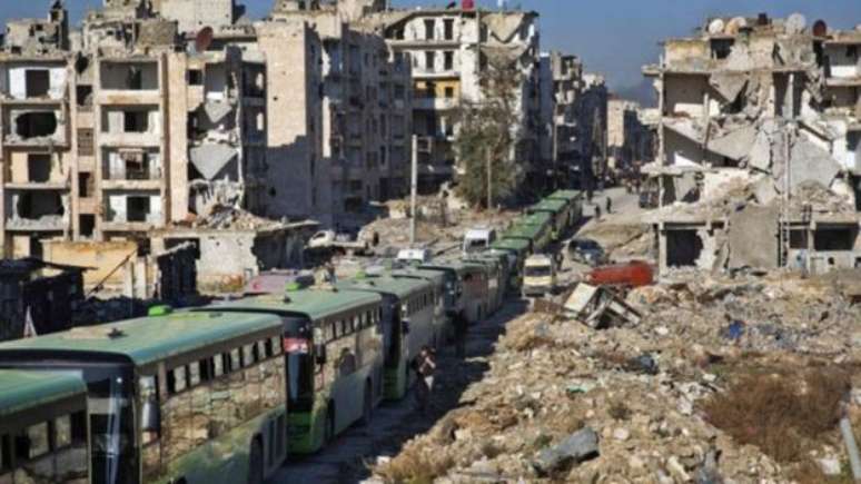 Comboio de ônibus aguarda a retirada de civis e rebeldes em Aleppo, na sexta-feira 