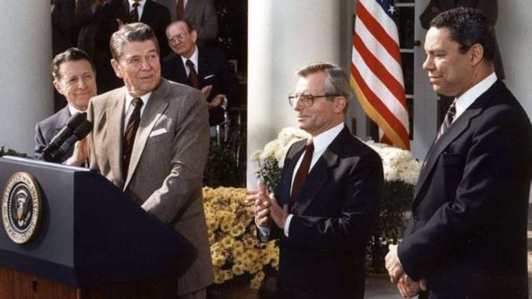 Ronald Reagan (segundo a partir da esq.) teve que ficar com os códigos nucleares dos EUA até o seu último momento no cargo por orientação do então assessor de Segurança Nacional (dir.) Colin Powell. 