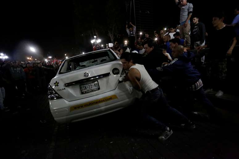 Manifestantes viram carro durante protesto contra aumento da gasolina em Monterrey, no México