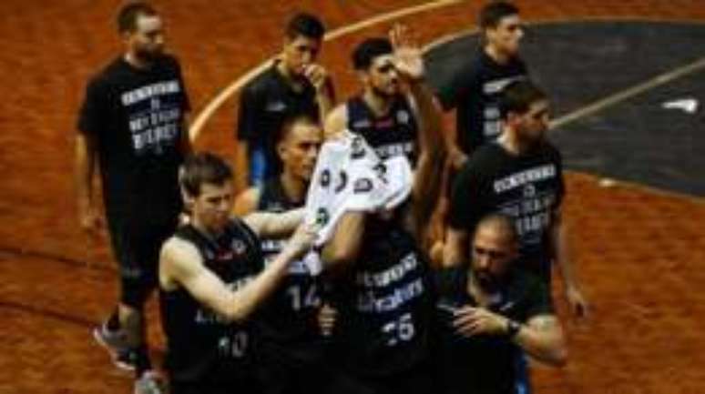 Com uma toalha cobrindo o rosto, Mitchell sa&uacute;da os torcedores