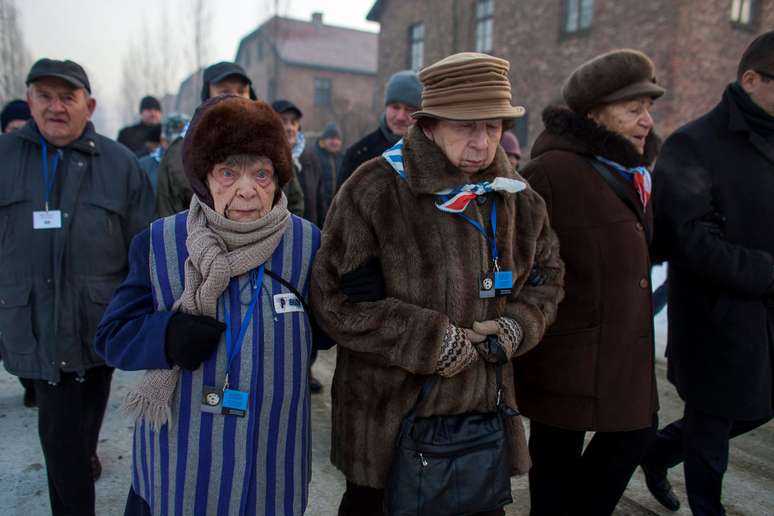 Sobreviventes caminham pelo campo de Auschwitz