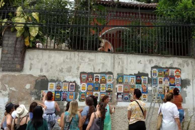 Rio de Janeiro - Público observa a instalação de mosaicos sobre o bondinho no bairro de Santa Teresa
