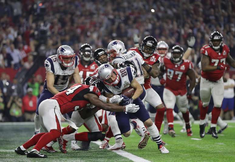 O wide-receiver Julian Eldeman atropela a defesa do Falcons para anotar um touchdown a favor do Patriots
