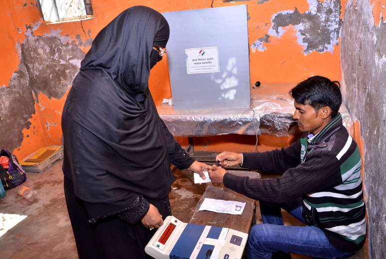 Mulher tem o dedo pintado depois de votar nas eleições na Índia