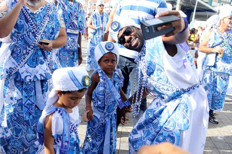 Ator faz selfie com filho durante desfile do grupo baiano