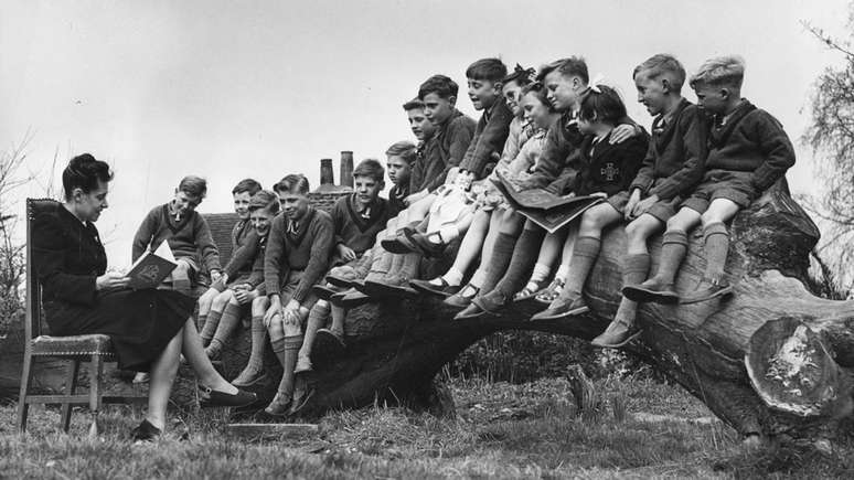 Professora lê para um grupo de crianças em Stevenage, antes de serem enviadas à fazenda de Fairbridge, em Molong.
