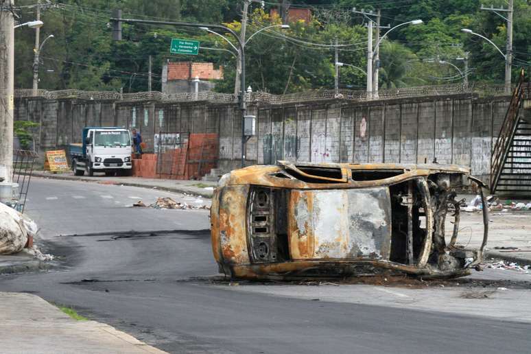 Veículos incendiados durante protesto contra morte de menina na Escola Municipal Daniel Piza, em Acari, seguem nas vias do bairro de Costas Barros, no Rio de Janeiro (RJ), na manhã desta sexta-feira (31)