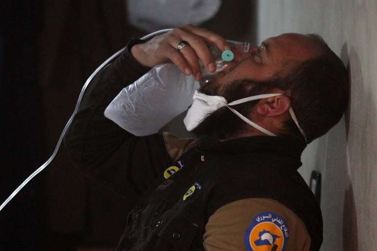Membro da Defesa Civil síria respira com ajuda de máscara de oxigênio após suposto ataque com gás