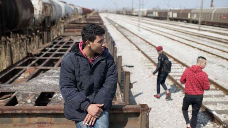 Migrantes esperam em Tessalônica pela oportunidade de embarcar em um trem de carga rumo à Alemanha