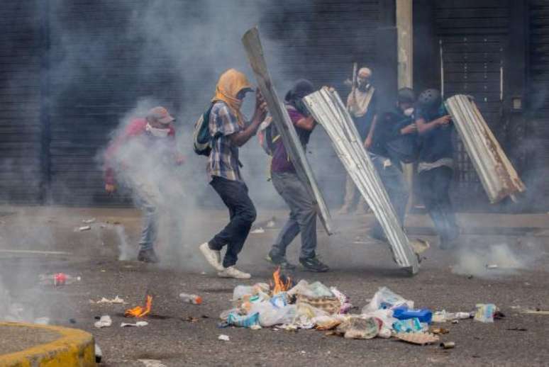 Manifestantes em Caracas, na Venezuela, entram em confronto com a Guarda Nacional do país, durante um protesto que pede a eleições no país e a saída de 