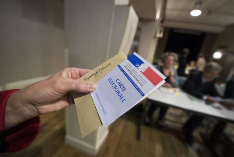 Eleitor mostra cédula de votação para eleição presidencial na França neste domingo 