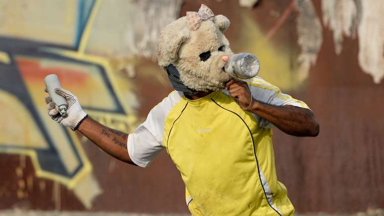 Manifestante em Caracas, na Venezuela, prestes a lan&ccedil;ar uma lata de g&aacute;s lacrimog&ecirc;neo