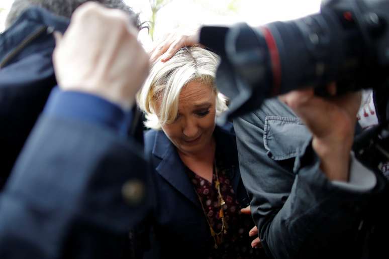 Segurança protege candidata Marine Le Pen, que foi recebida com ovos e insultos durante uma visita de campanha