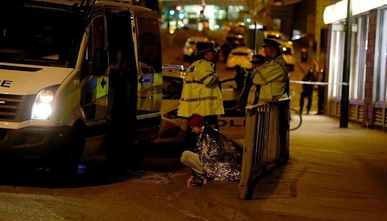 Fãs da cantora Ariana Grande são atendidos por equipes de resgate após explosão na Manchester Arena.