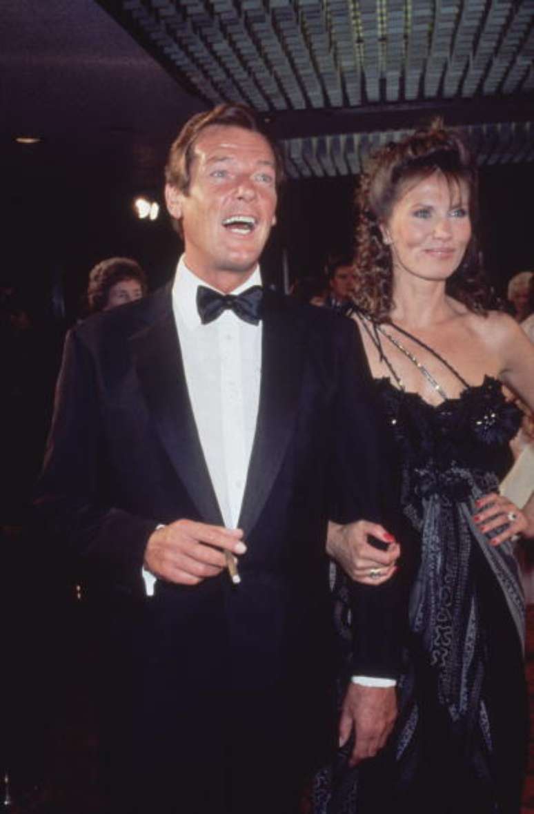 Em foto de 1983, Roger Moore chega acompanhado da atriz Maud Adams à première do filme &#039;007 contra Octopussy&#039;