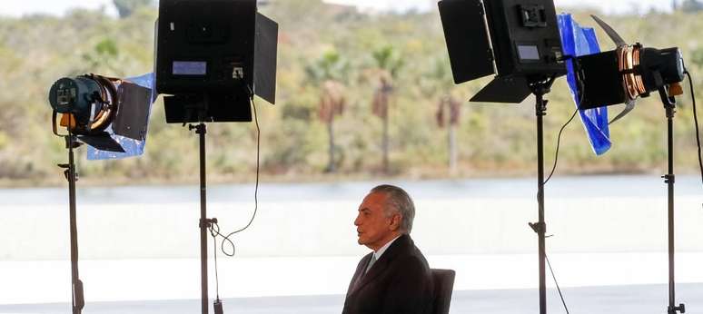 O presidente Michel Temer cercado por refletores em gravação para TV