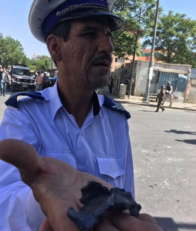 Policial mostra pedaço de estilhaço da explosão