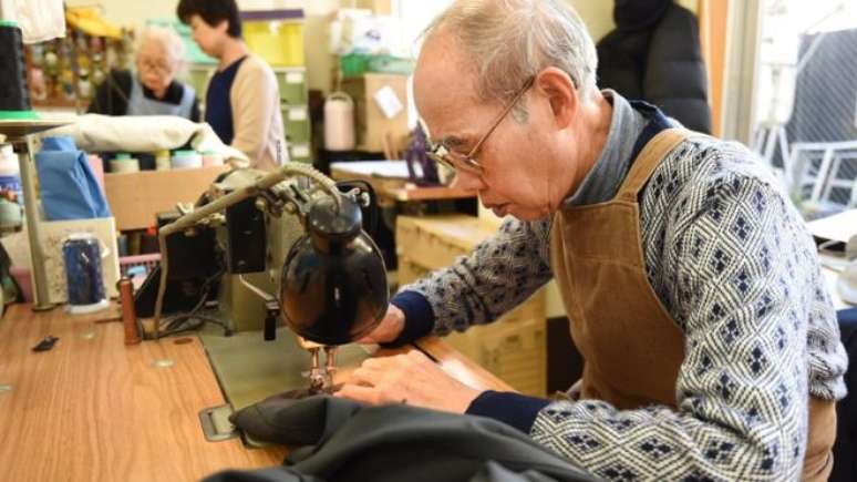 Japonês idoso trabalha em confecção. Expectativa de vida da população que nasce hoje será de 107 anos.