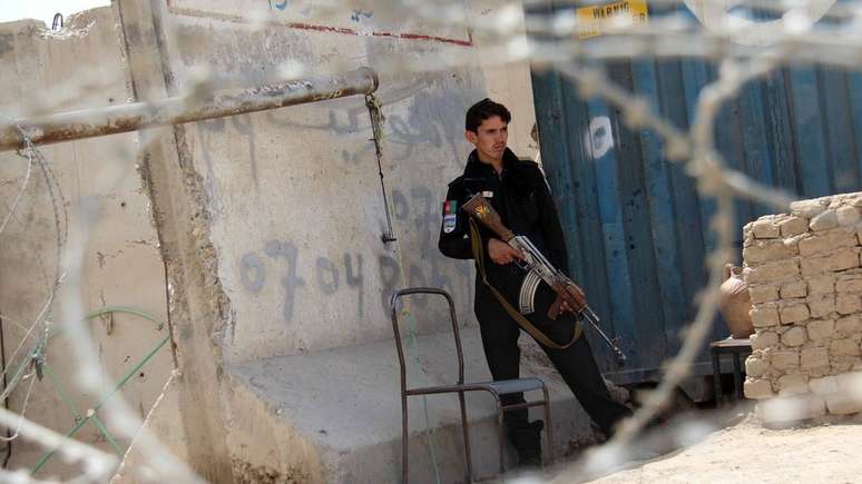 Policial afeg&atilde;o monta guarda em posto de checagem