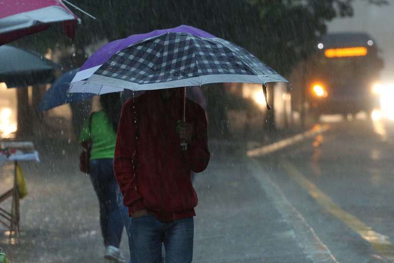 Pedestre se protege da chuva na avenida 23 de Maio, altura do viaduto Paraíso, em São Paulo (SP), na manhã desta terça-feira (6).