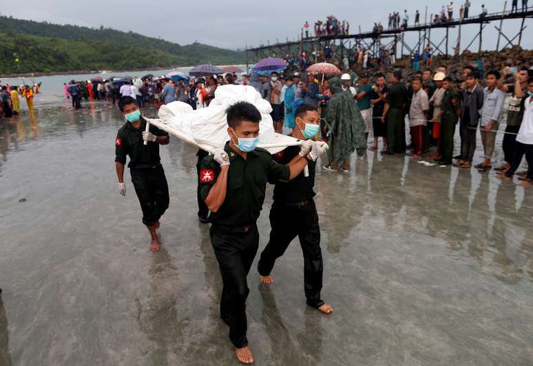 Soldados carregam corpos de militares mortos em queda de avião em Myanmar.