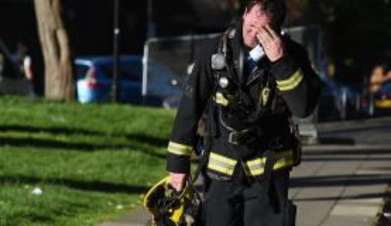 Bombeiro deixa as imediações da Grenfell Tower desolado, após combater incêndio em edifício de 24 andares, em Londres
