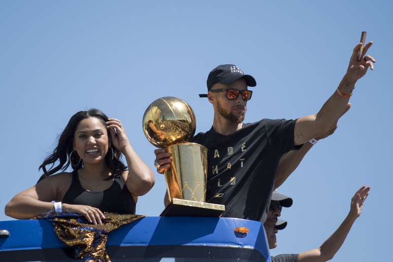 Stephen Curry acena para a multidão, ao lado da mulher Ayesha Curry