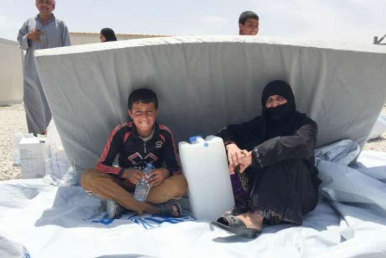 Famílias buscam abrigo no novo acampamento para deslocados do Acnur, no Iraque 