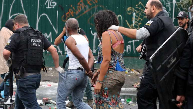 Mulher conduzida por policial em ação na cracolândia