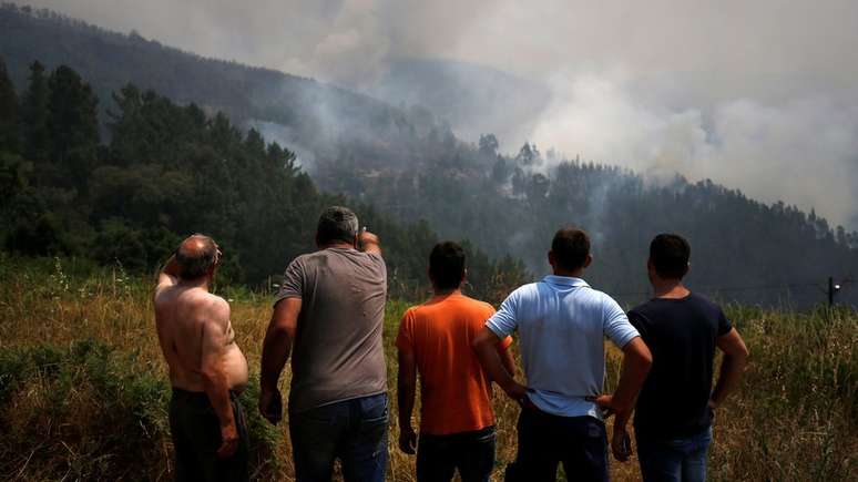 Homens observam inc&ecirc;ndio em Portugal &agrave; dist&acirc;ncia