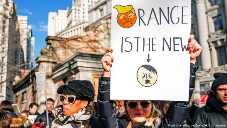 Em protesto em janeiro deste ano, manifestante em Nova York segura cartaz que compara Donald Trump a Adolf Hitler