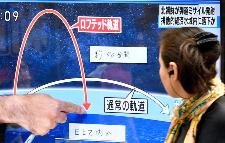 Pedestre vê reportagem sobre lançamento de míssil no Japão