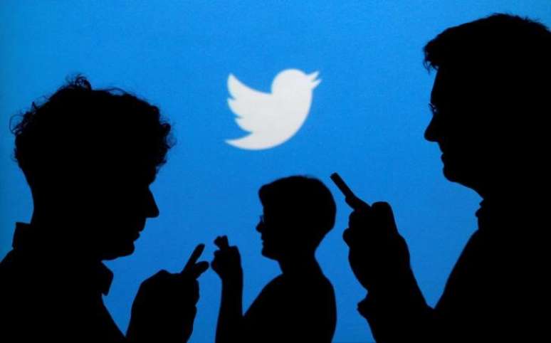 Pessoas usam celulares diante de logo do Twitter, uma das empresas que se manifestaram contra as mudanças nas regras de neutralidade da rede
27/11/2013 REUTERS/Kacper Pempel