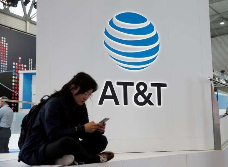 Mulher usa celular diante do logo da AT&T durante o Mobile World Congress em Barcelona
25/02/2016 REUTERS/Albert Gea/File Photo