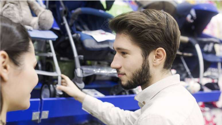 Casal comprando carrinho de beb&ecirc;