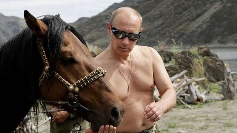 Vladimir Putin em uma imagem que marcou a sua imagem: sem camisa e alimentando um cavalo 
