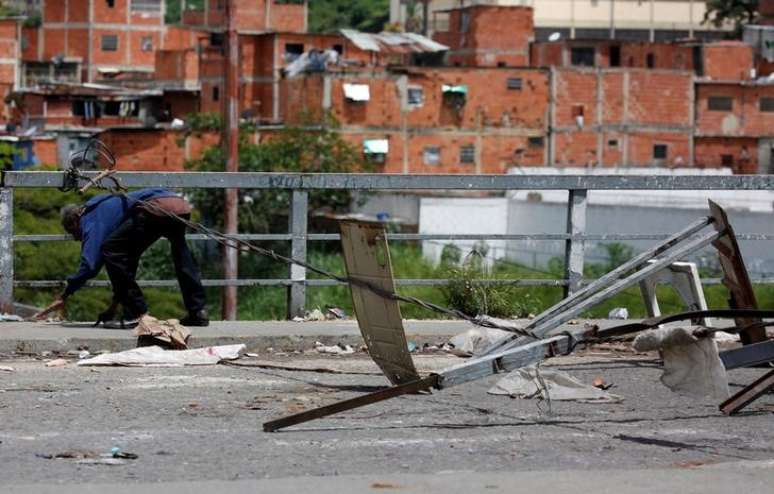 Homem passa por baixo de fio usado para bloquear rua durante greve convocada em protesto contra o presidente venezuelano, Nicolás Maduro em Caracas
20/07/2017 REUTERS/Carlos Garcia Rawlins